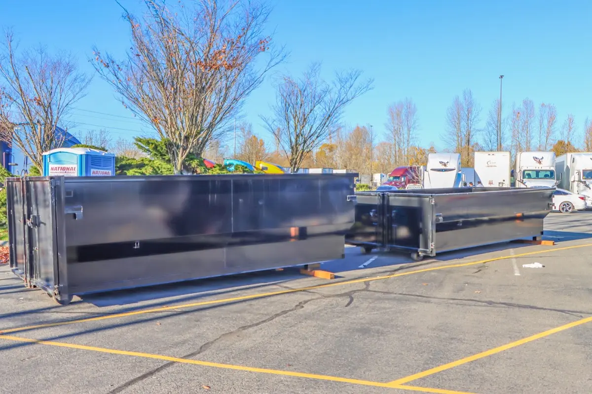 Professional dumpster rental service with roll-off container on residential driveway in Lenoir